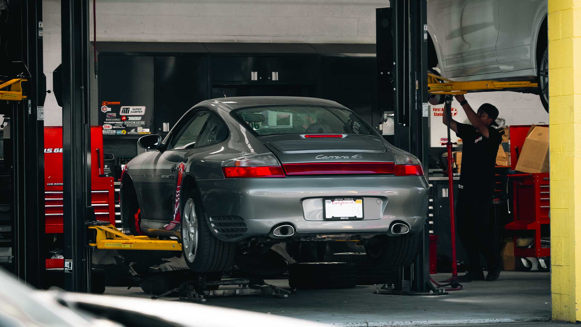 gray porsche 996 911 on lift at house automotive shop