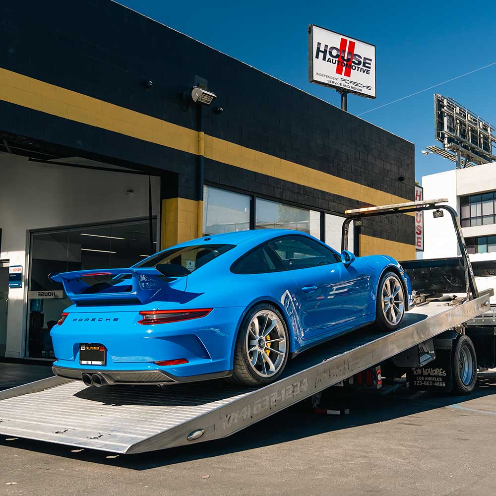 blue porsche 911 gt3 flatbed towed to house automotive