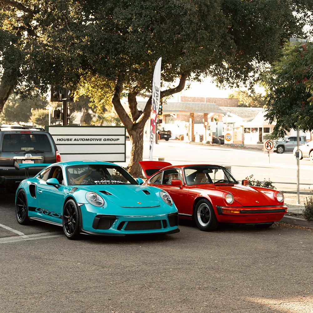 blue porshce 911 gt3 rs and red porsche 911 classic at house automotive shop