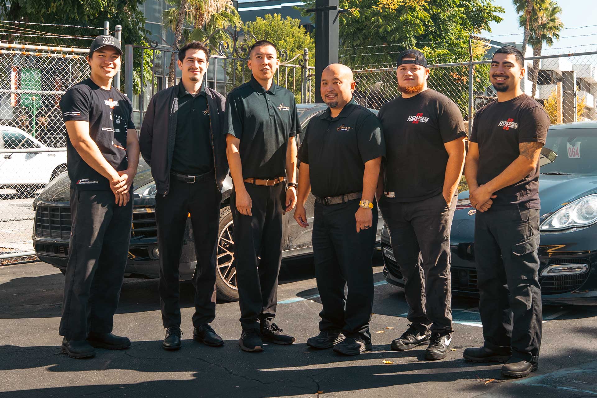 house automotive encino team standing in front of porsche cars are service center