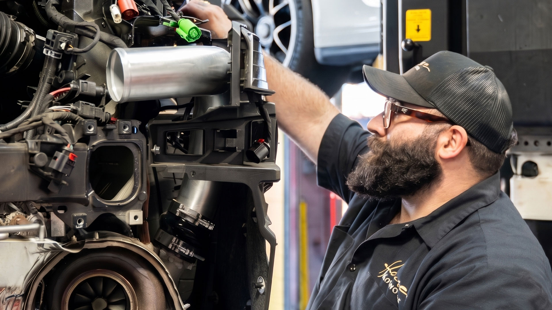 house automotive technician working on a porsche engine in the shop