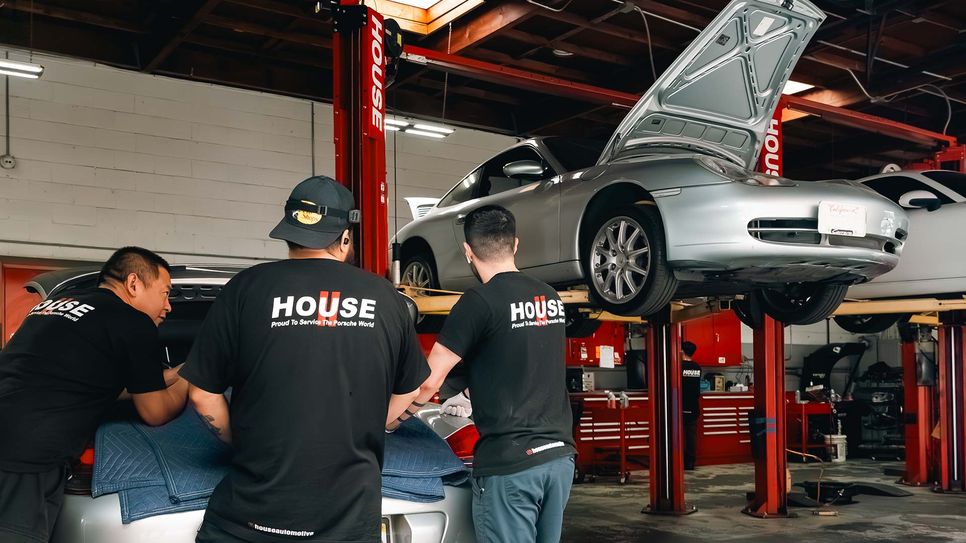 house ag techs working together on a silver porsche