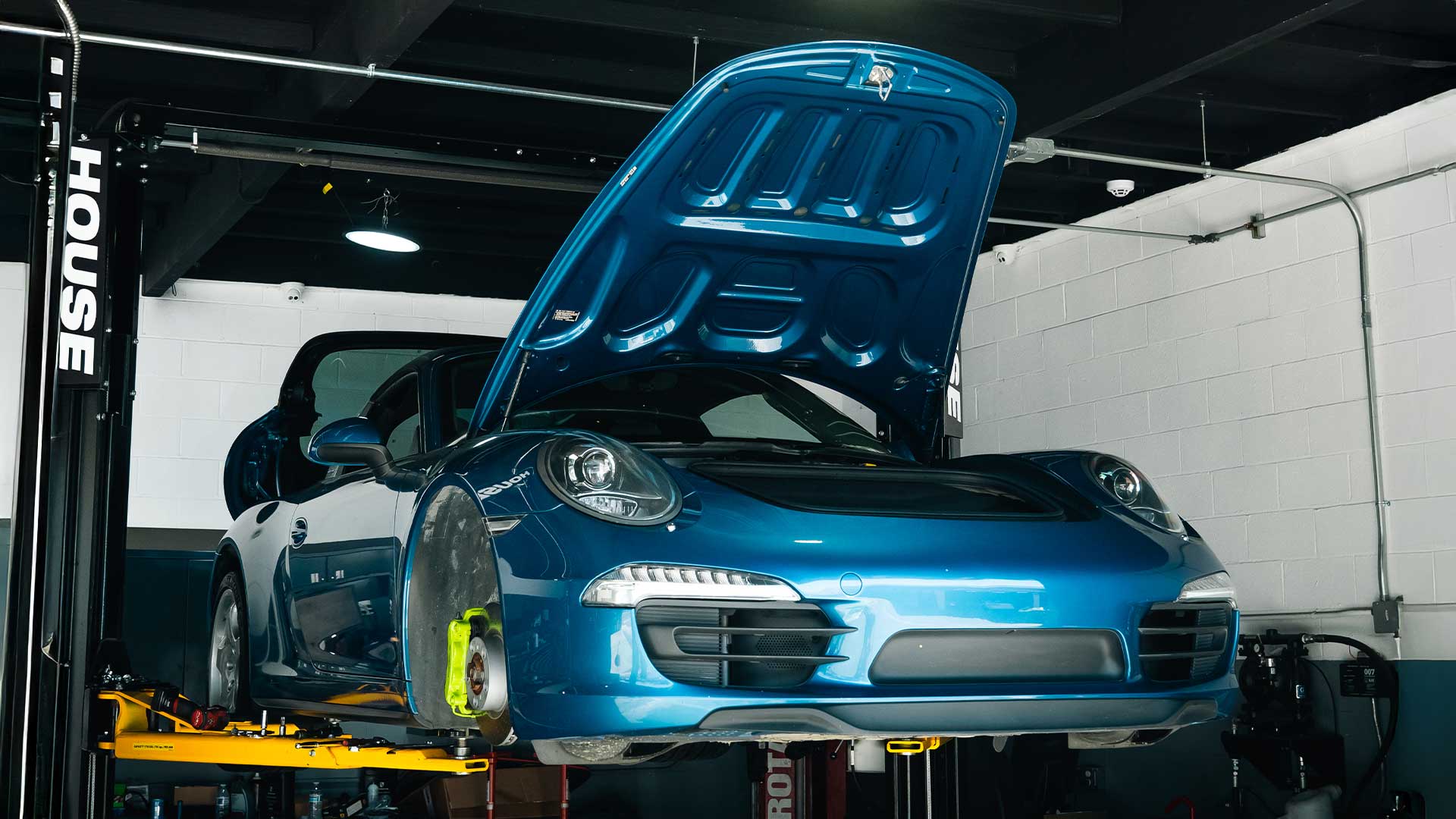 blue porsche 911 991 on lift at house automotive porsche service center los angeles