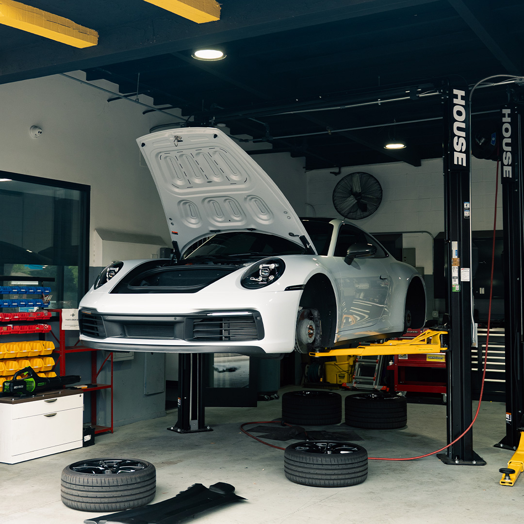 white 911 carrera on lift house automotive pasadena