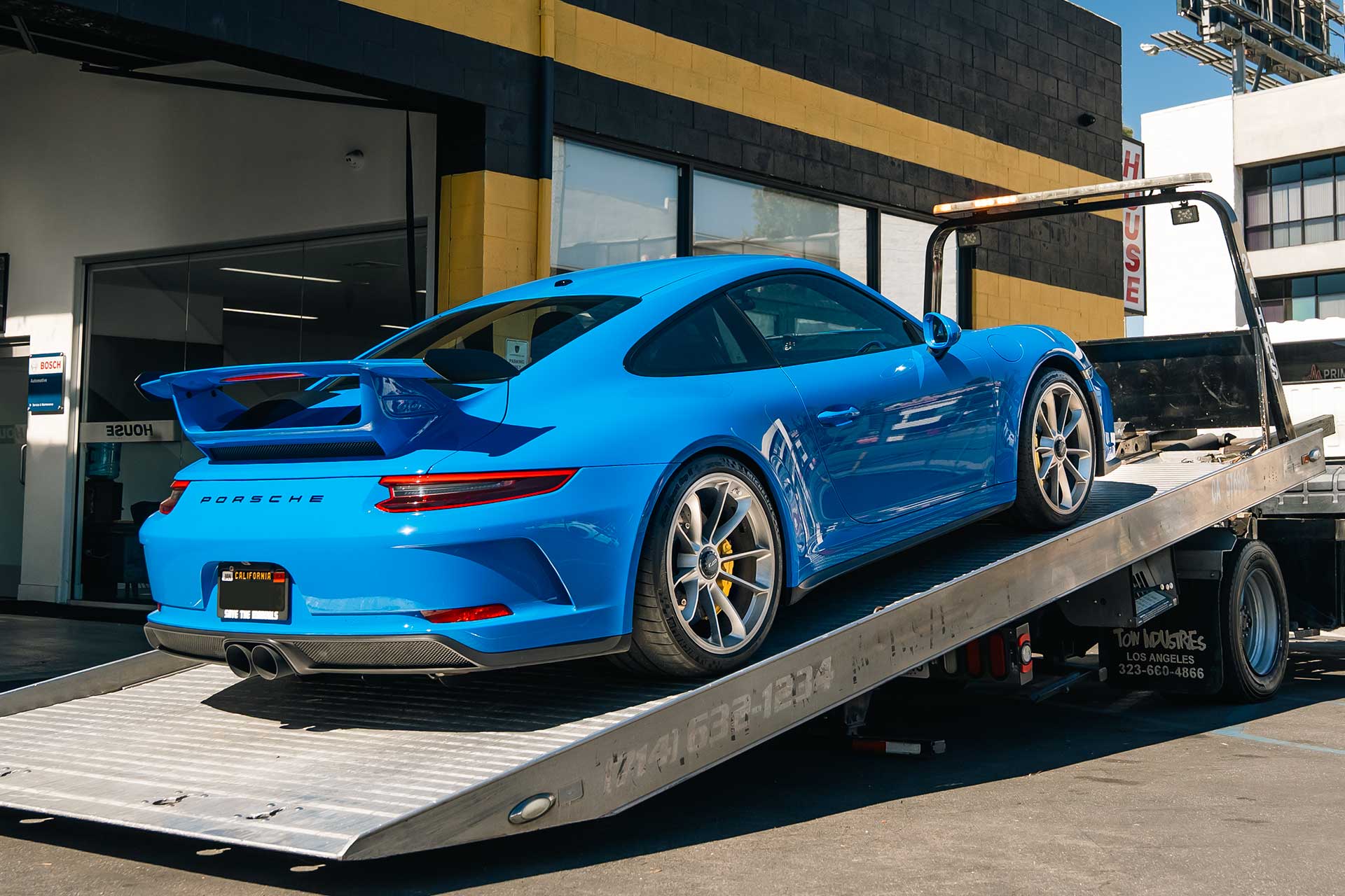 blue porsche 911 gt3 being towed