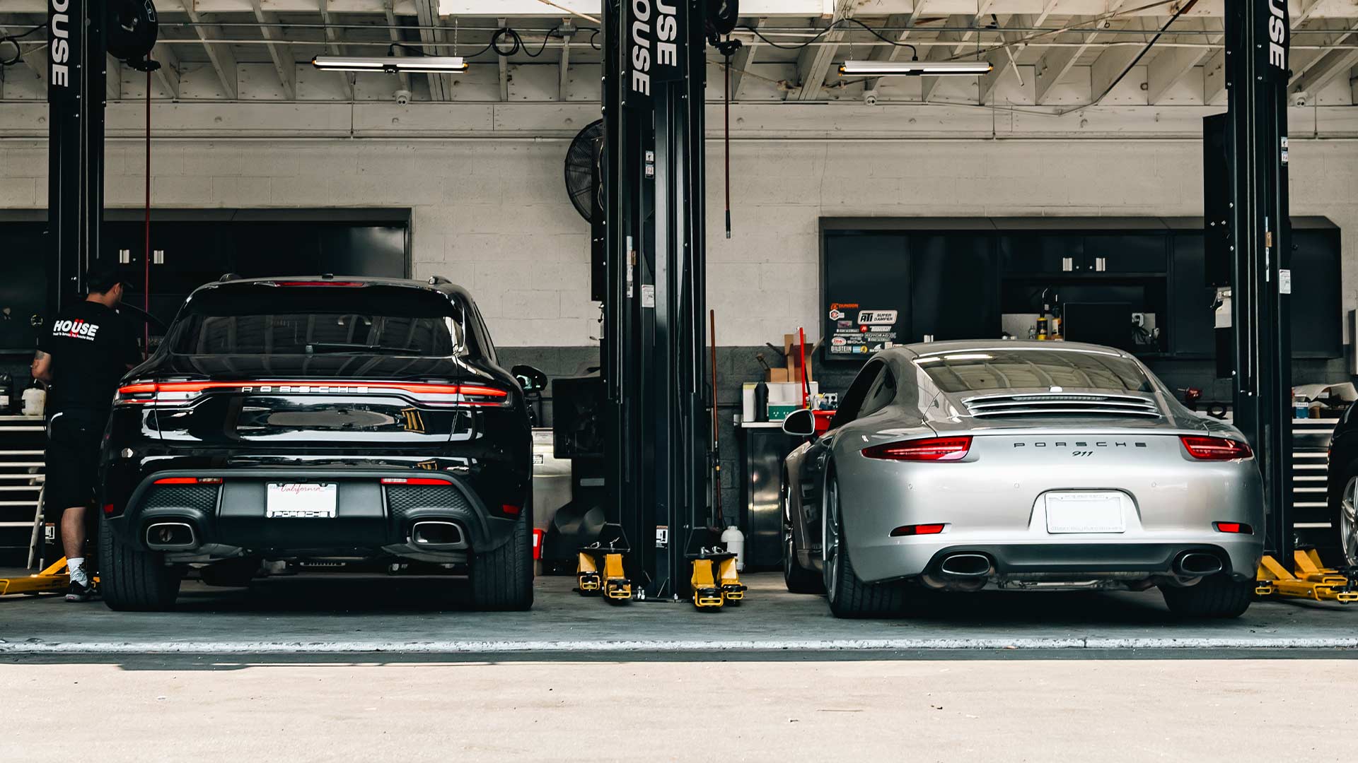 porsche macan and porche 911 in bays at house automotive