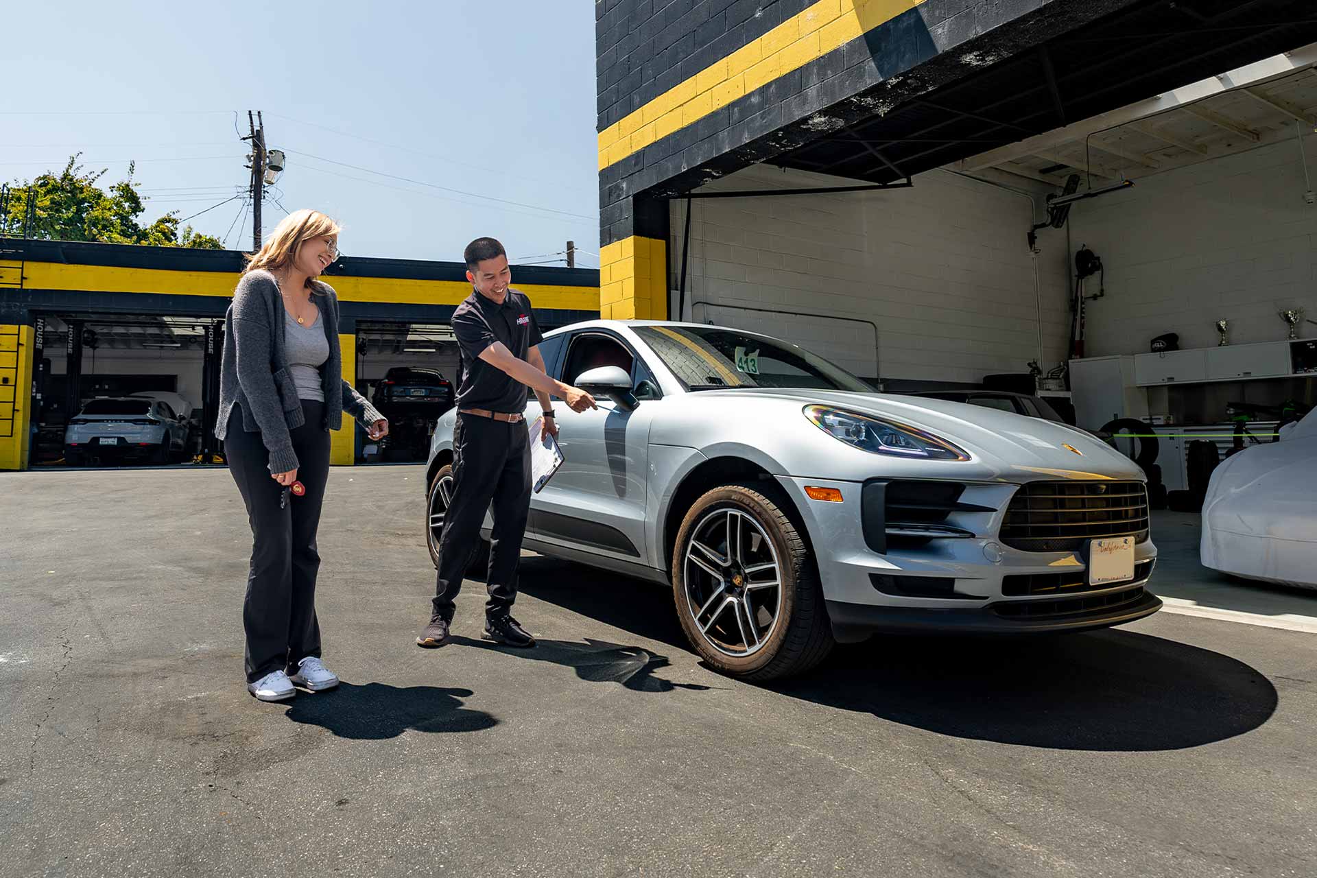 porsche service advisor explaining macan inspection results to customer at house automotive