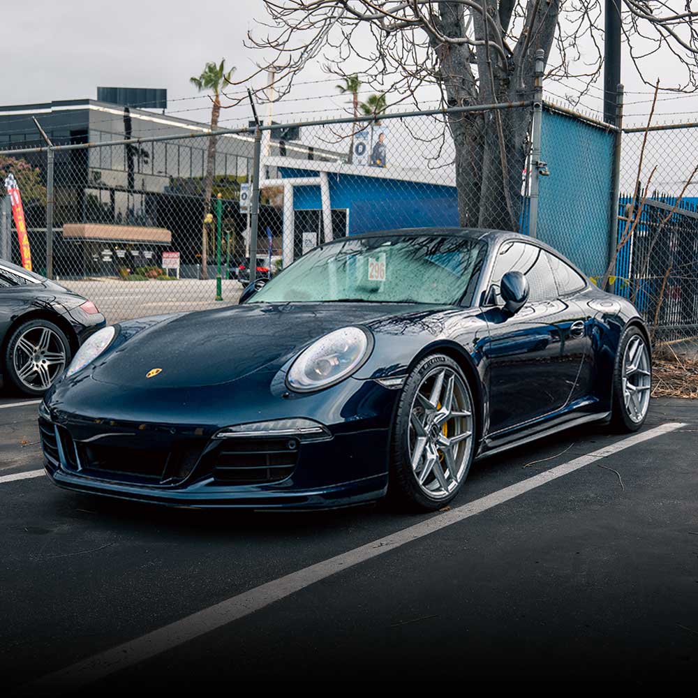 dark blue porsche 911 being serviced at house automotive independent shop in los angeles