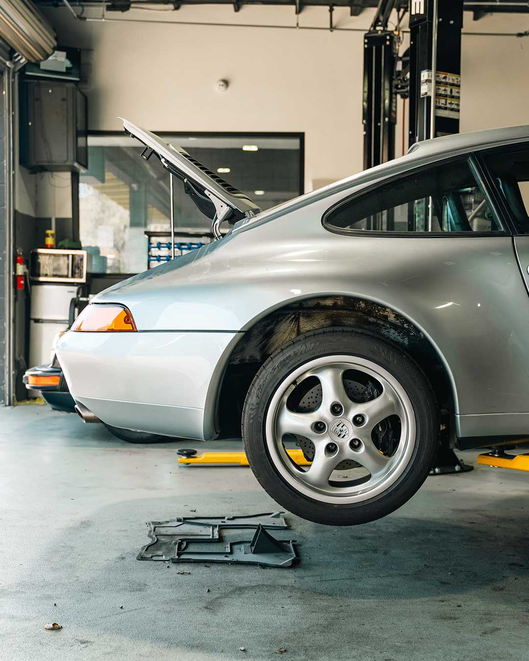 silver porsche 911 on lift at house auto