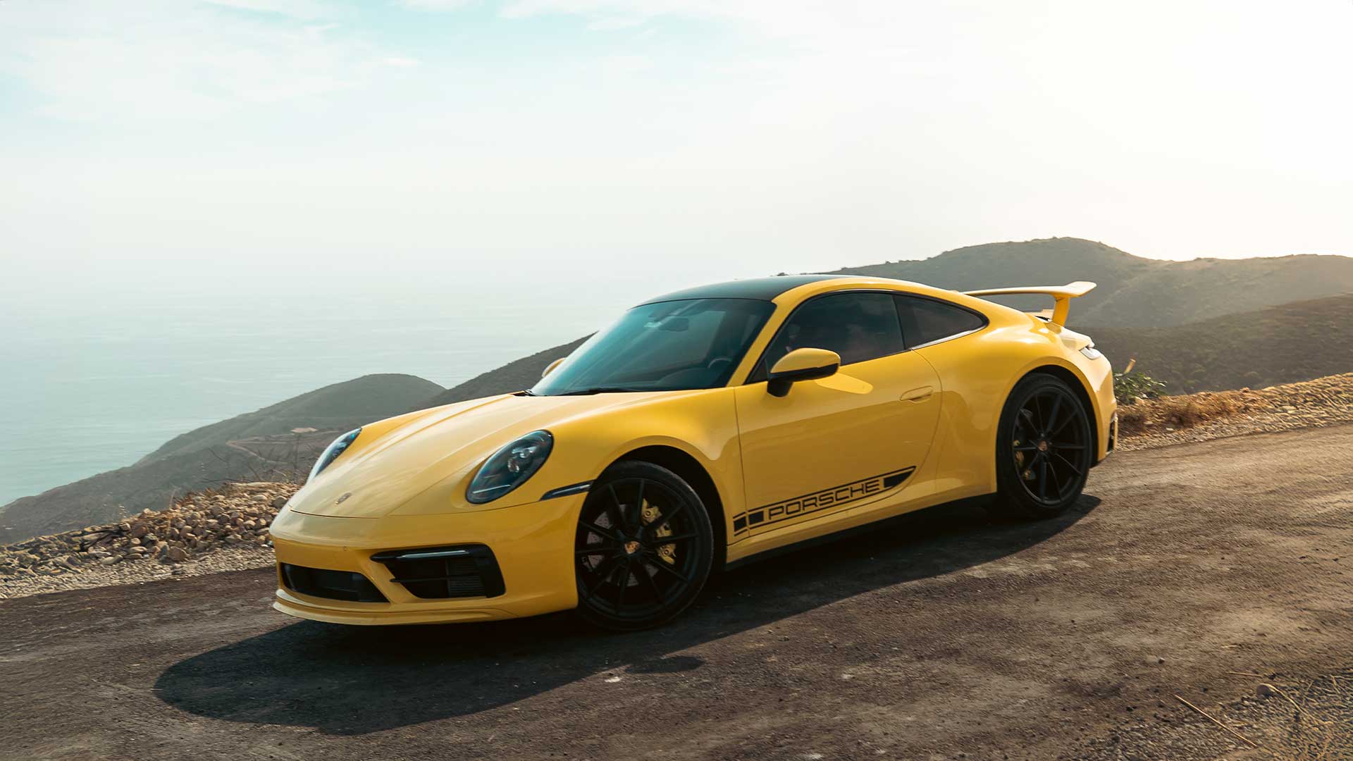 speed yellow 992 porsche 911 gts on pacific coast highway