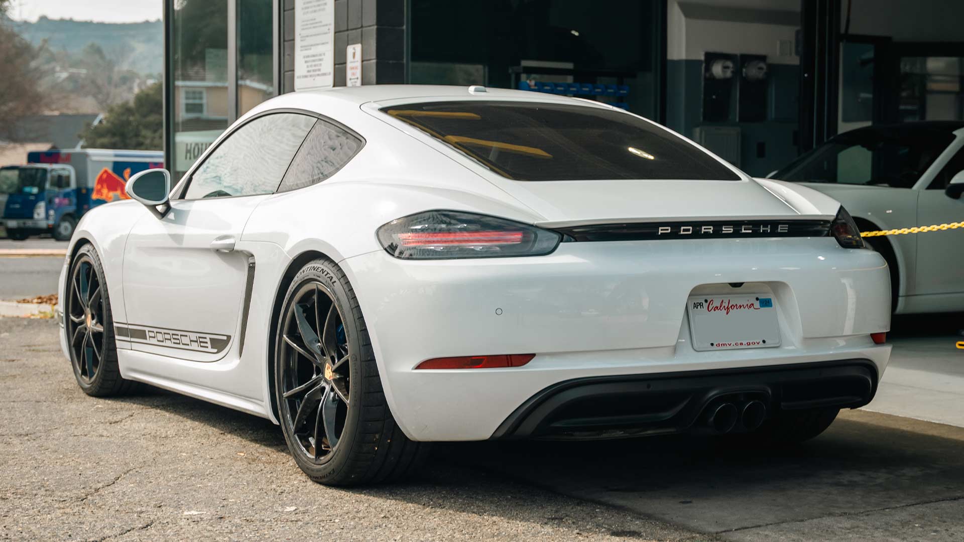 white porsche 718 at house automotive porsche service center